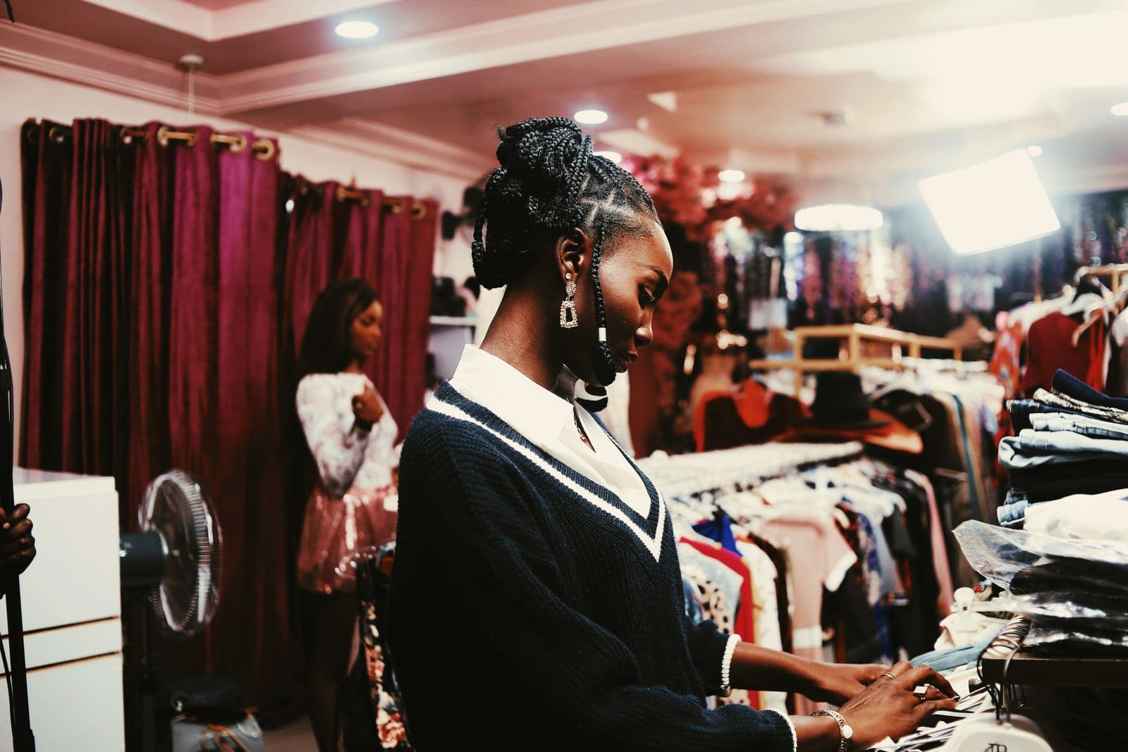 A shopper browsing racks of clothing in a boutique